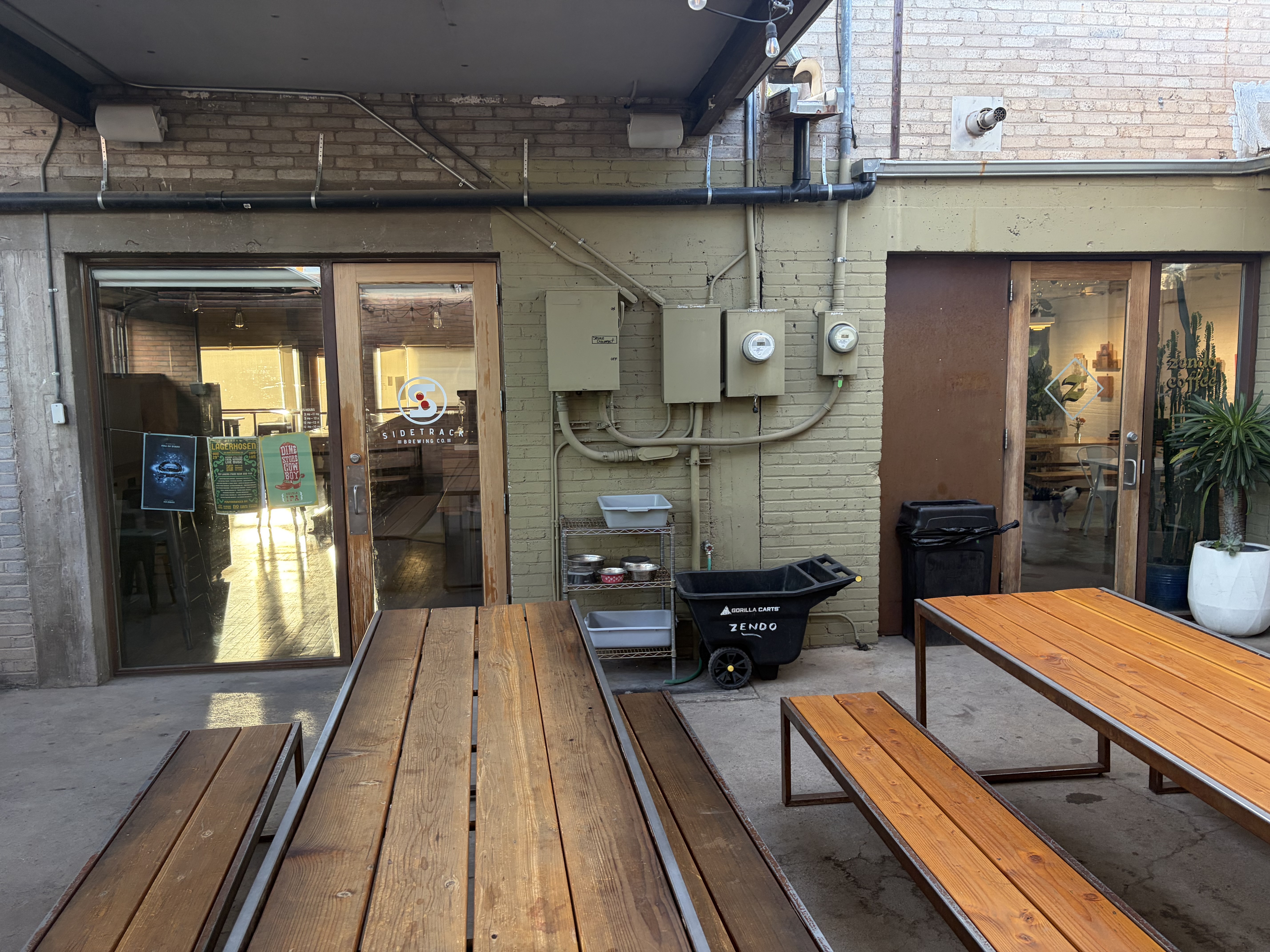A shared courtyard: the Sidetrack Brewing door on the left, the Zendo door on the right, a cart lettered ZENDO between them.